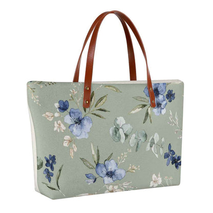 Floral rectangular beach tote with brown handles on sage green background