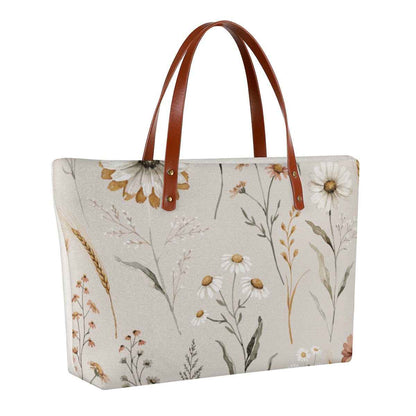 White floral canvas tote bag with brown leather-look handles and wide top opening.