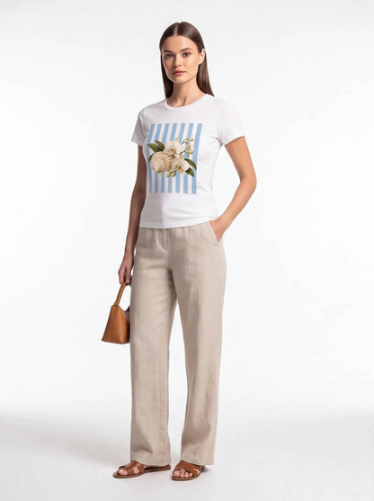 White crewneck t-shirt with centered blue striped seashell and orchid graphic