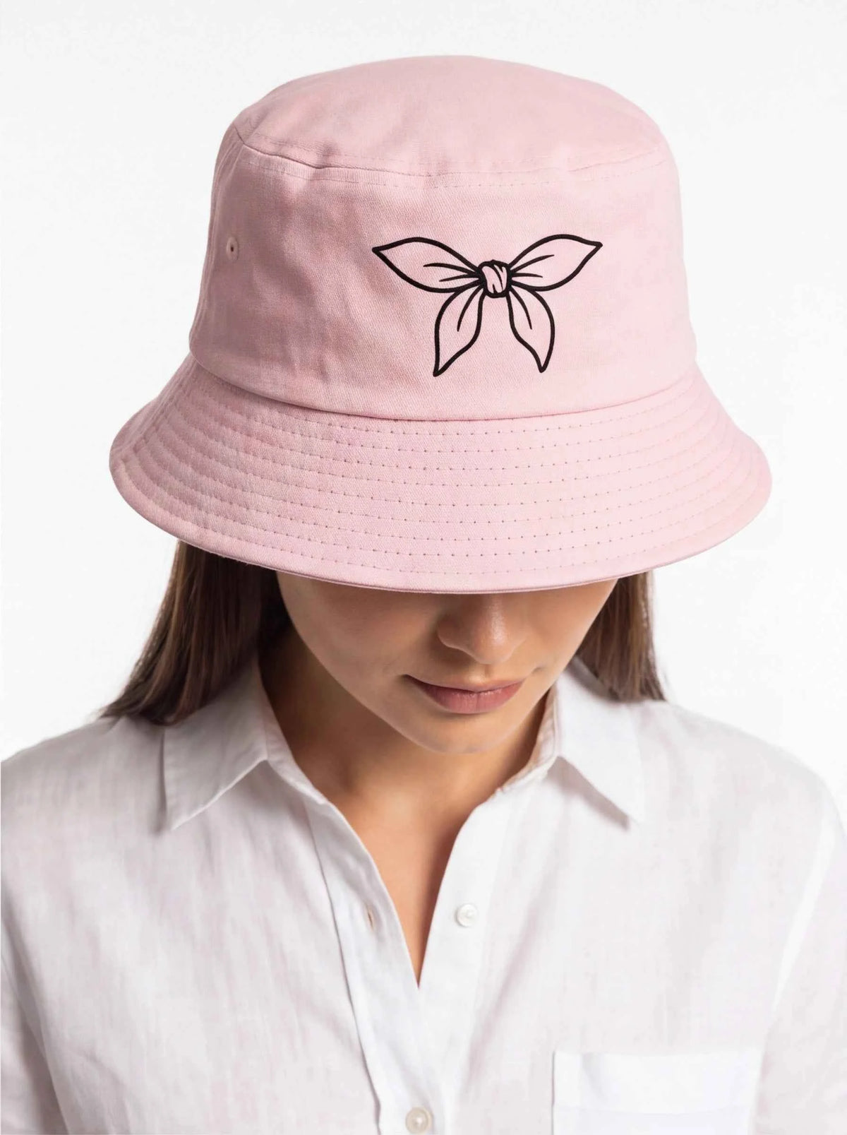 Blush pink bucket hat close-up with embroidered bow ribbon on front
