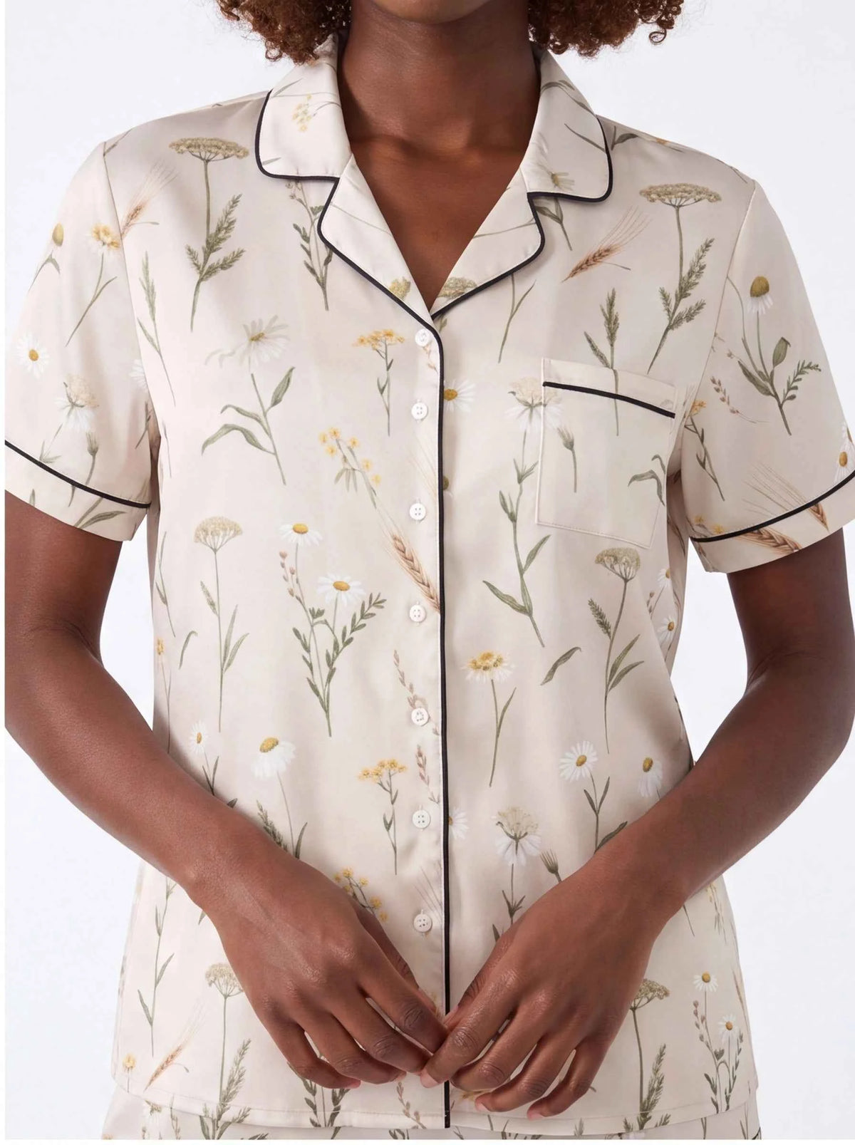 Close-up of cream botanical satin short-sleeve pajama shirt with button placket