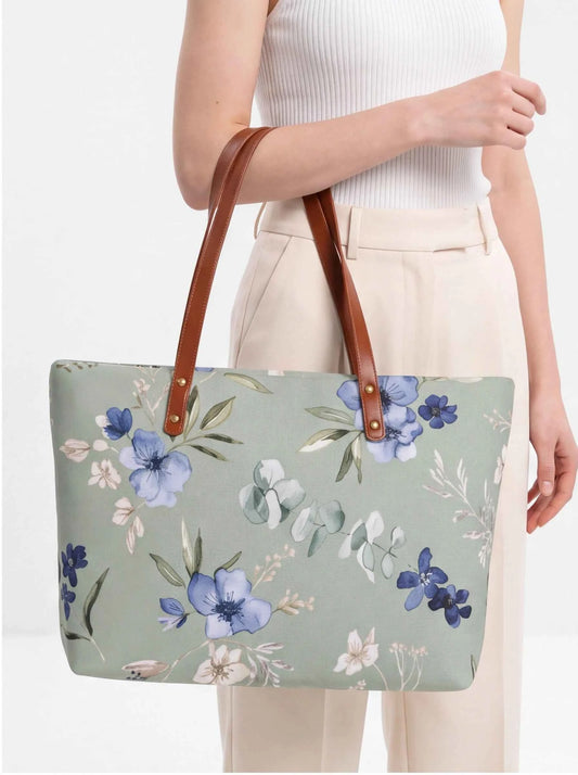 Floral sage beach tote with brown leather-look handles held at the side