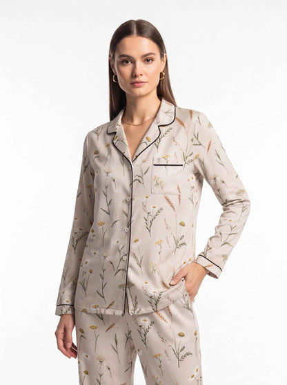 Women's satin lounge pajama set with botanical-print top and matching trousers, cream